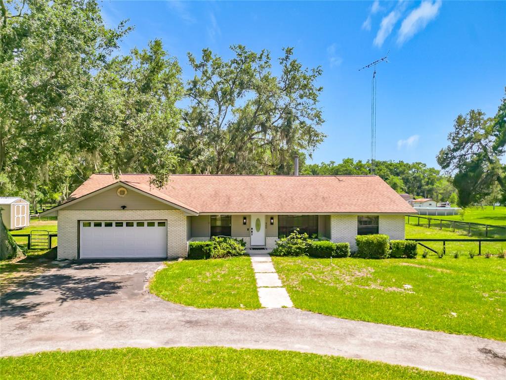 A single-story brick house with a two-car garage and a large front yard — 900 NE 165TH STREET, CITRA, FL