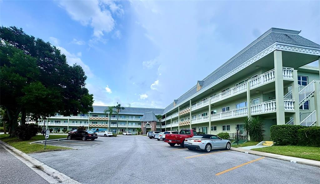 A multi-story apartment building with balconies and a parking lot in the foreground — 2459 COLUMBIA DRIVE UNIT 69, CLEARWATER, FL