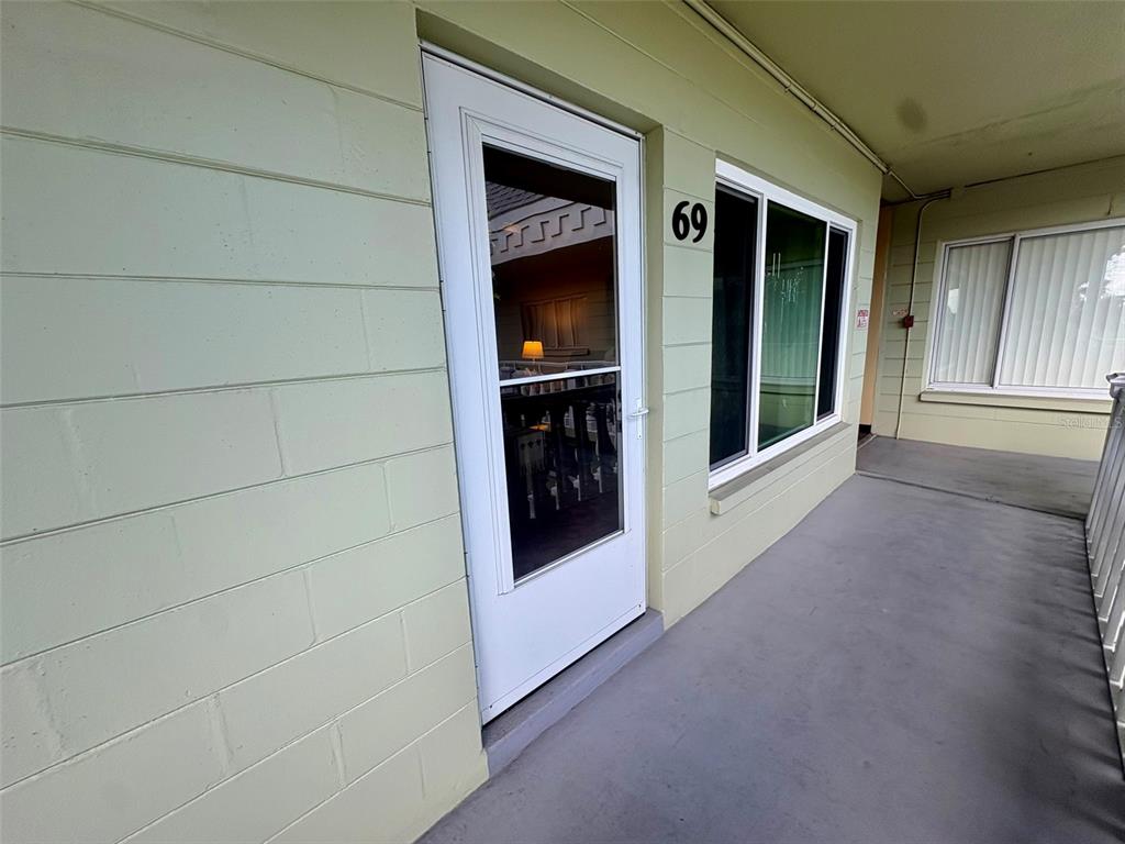 A light green exterior wall features a white door labeled 69 and a large window — 2459 COLUMBIA DRIVE UNIT 69, CLEARWATER, FL
