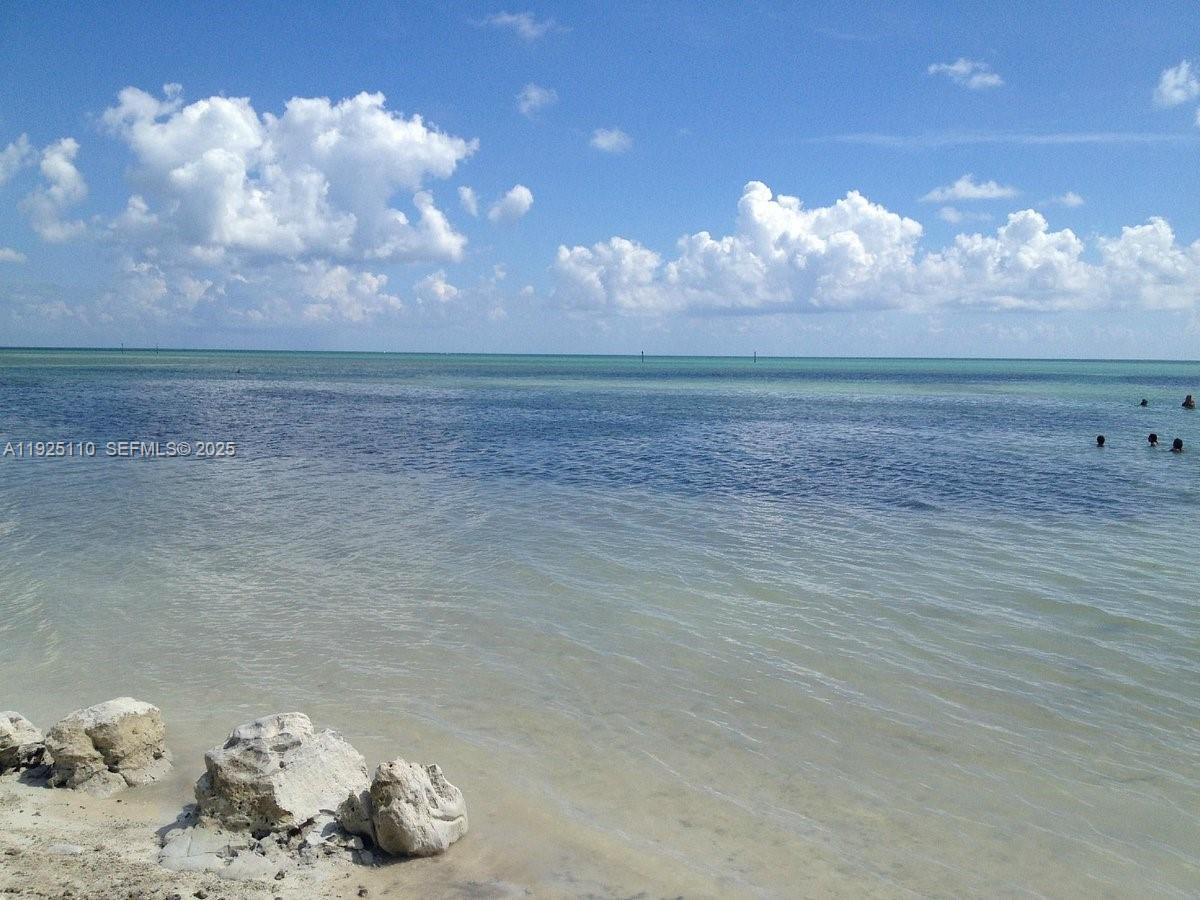 A view of a shallow, clear ocean with rocky shoreline and scattered clouds above — 29 Bonefish Ave, Key Largo FL 33037, KEY LARGO, FL