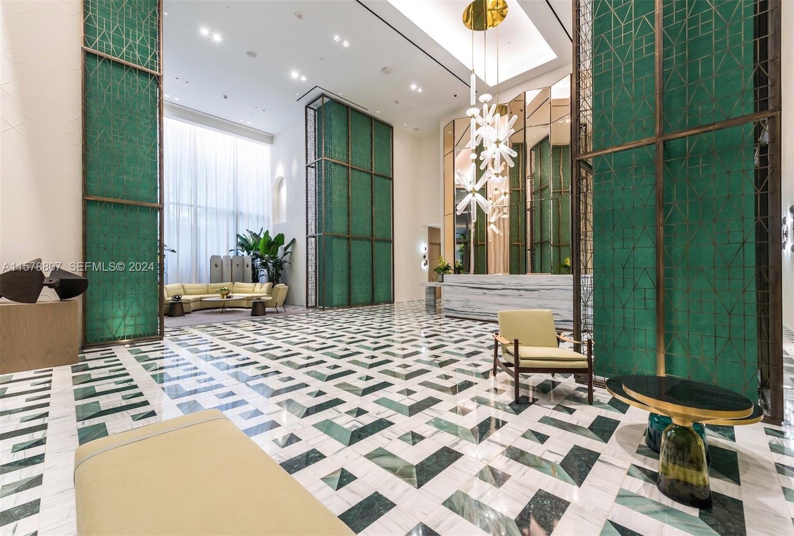 A modern lobby features a geometric marble floor, green decorative screens, and a sculptural chandelier — 801 S Miami Ave # 3009, Miami FL 33130, MIAMI, FL