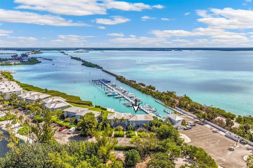 An aerial view shows a waterfront condominium building with a boat slip marina — 5850 GASPARILLA ROAD UNIT M4, BOCA GRANDE, FL
