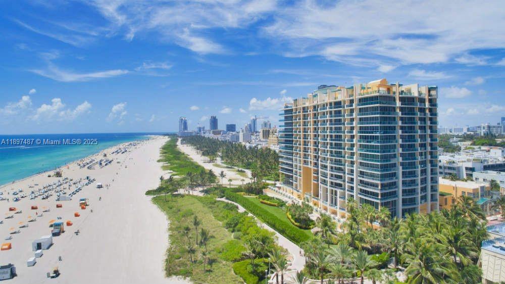 An aerial view shows a large beachfront condominium building next to a sandy beach — 1455 Ocean Dr # 1003, Miami Beach FL 33139, MIAMI BEACH, FL