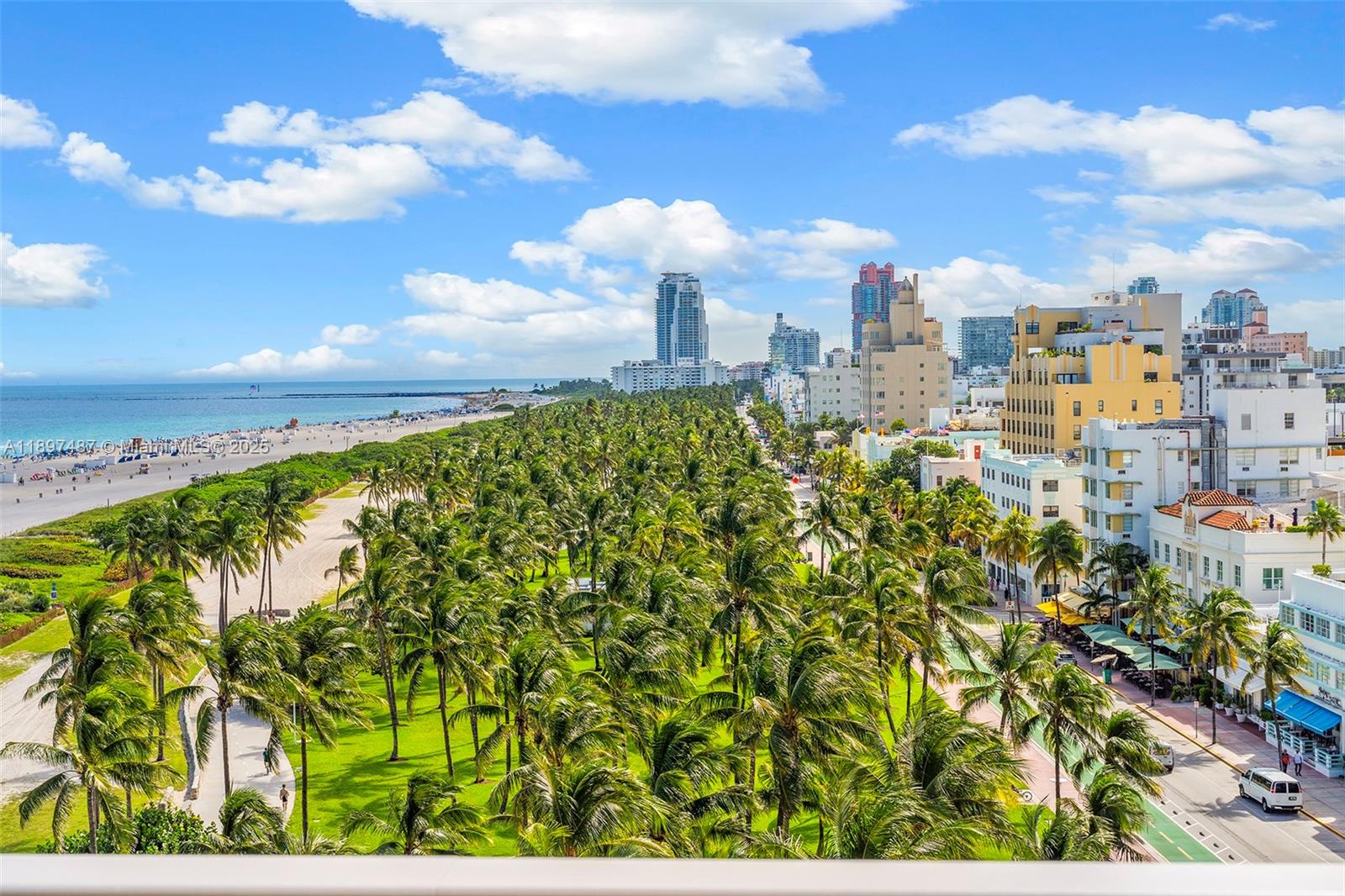 An elevated view shows a beach, a palm-filled park, and city buildings under a blue sky — 1455 Ocean Dr # 1003, Miami Beach FL 33139, MIAMI BEACH, FL