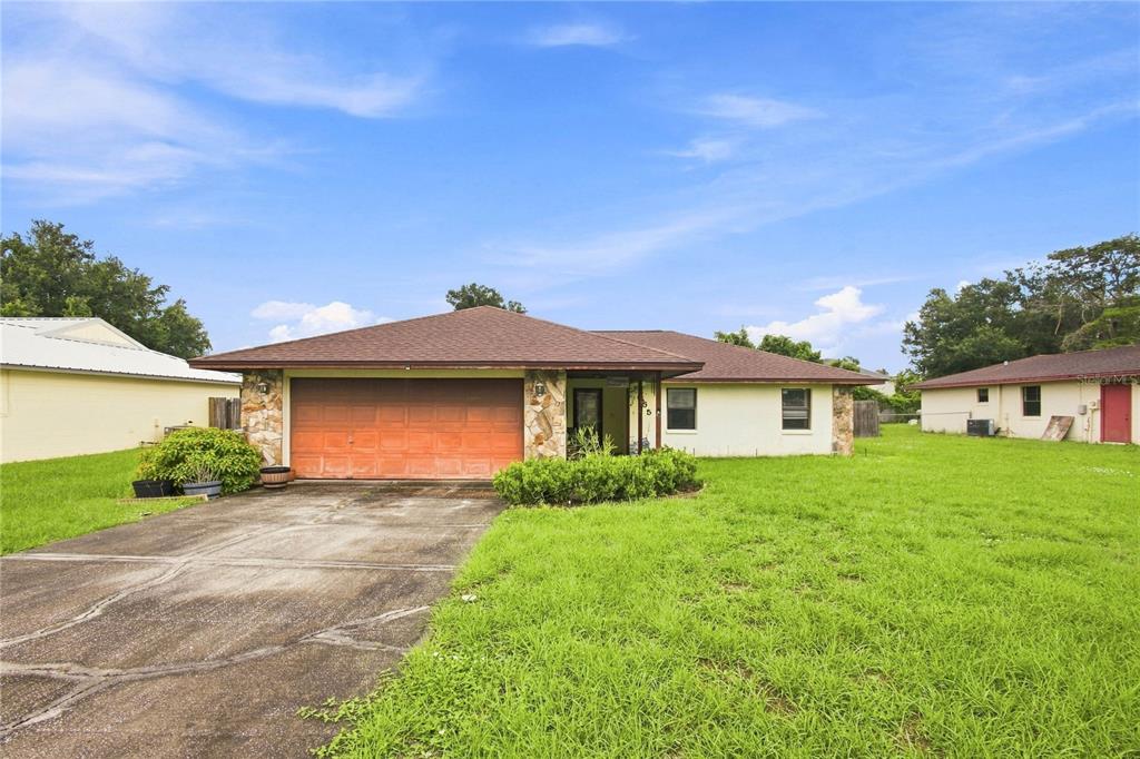 A single-story house with a brown roof, stone accents, and a two-car garage — 5055 CAMBRY LANE, LAKELAND, FL