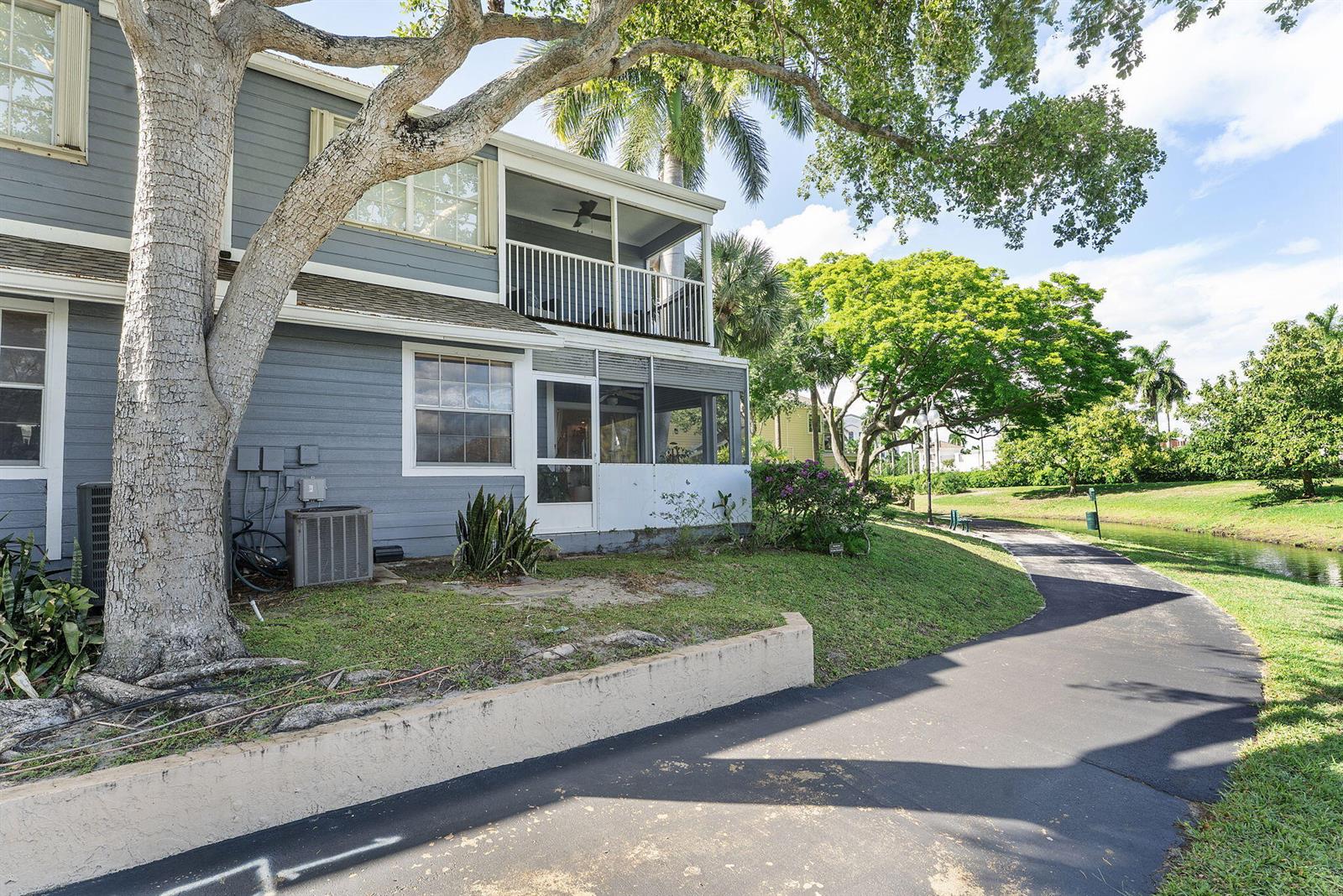 A two-story blue house with screened porches sits next to a paved walking path — 5272 Buckhead Circle # 1010, Boca Raton FL 33486, BOCA RATON, FL