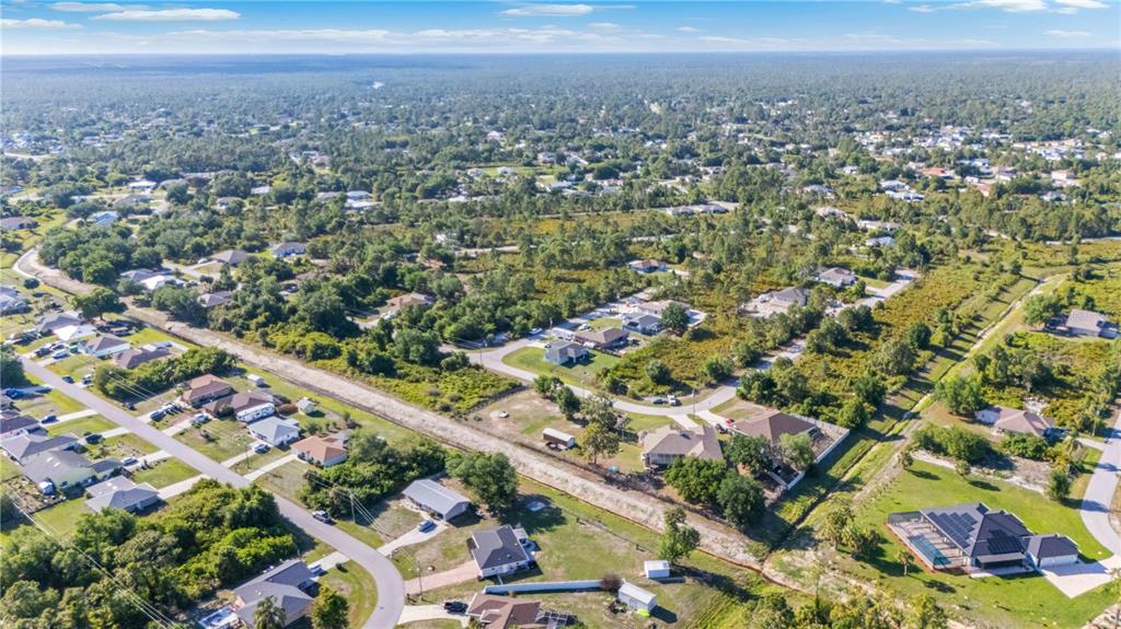 An aerial view of a single-story house with a brick driveway and a large lawn — 7124 TOTEM AVENUE, NORTH PORT, FL