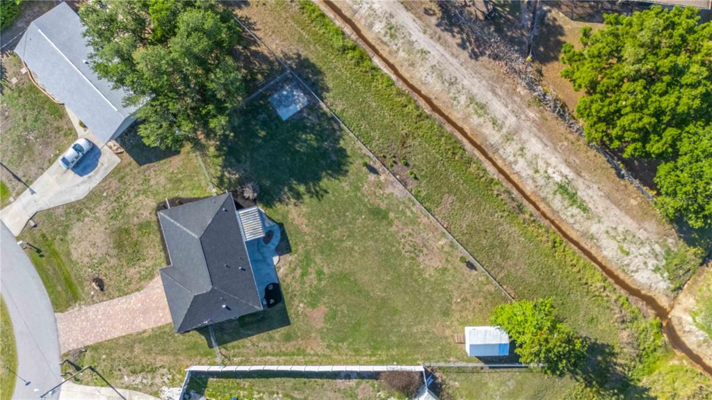 An aerial view shows a house with a large backyard, a shed, and a fence — 7124 TOTEM AVENUE, NORTH PORT, FL