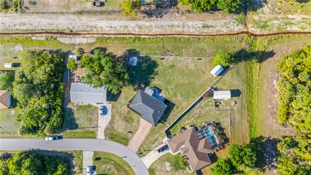 A single-story house with a gray stucco exterior, a paver driveway, and a shingled roof — 7124 TOTEM AVENUE, NORTH PORT, FL