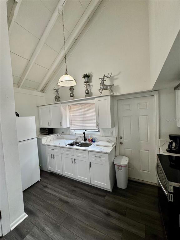 A kitchen with white cabinets, dark wood-look flooring, and a high vaulted ceiling — 12315 TOUCHTON DRIVE UNIT 90, TAMPA, FL