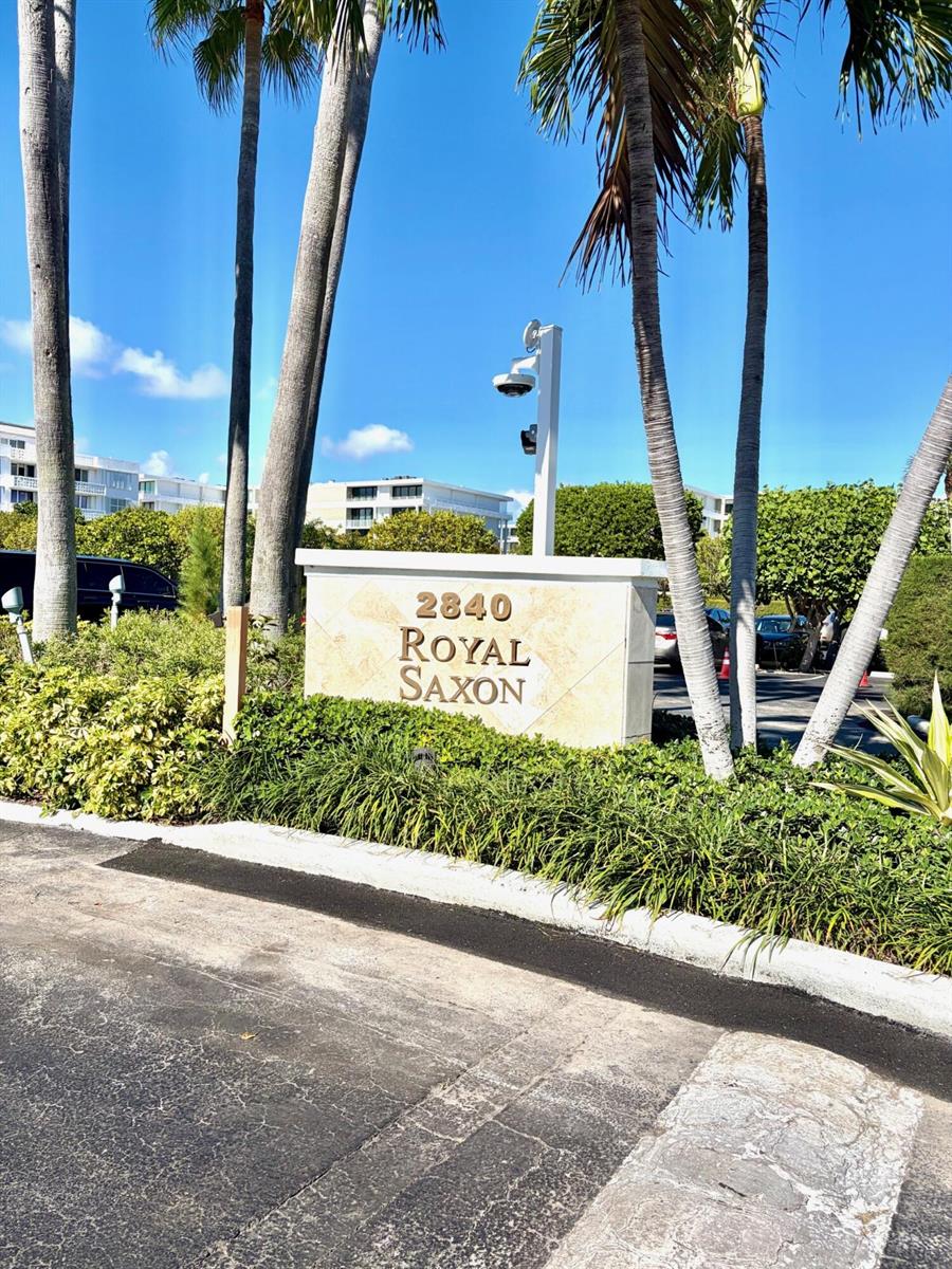 A stone sign for the Royal Saxon stands outdoors surrounded by palm trees and landscaping — 2840 S Ocean Boulevard # 2050, Palm Beach FL 33480, PALM BEACH, FL