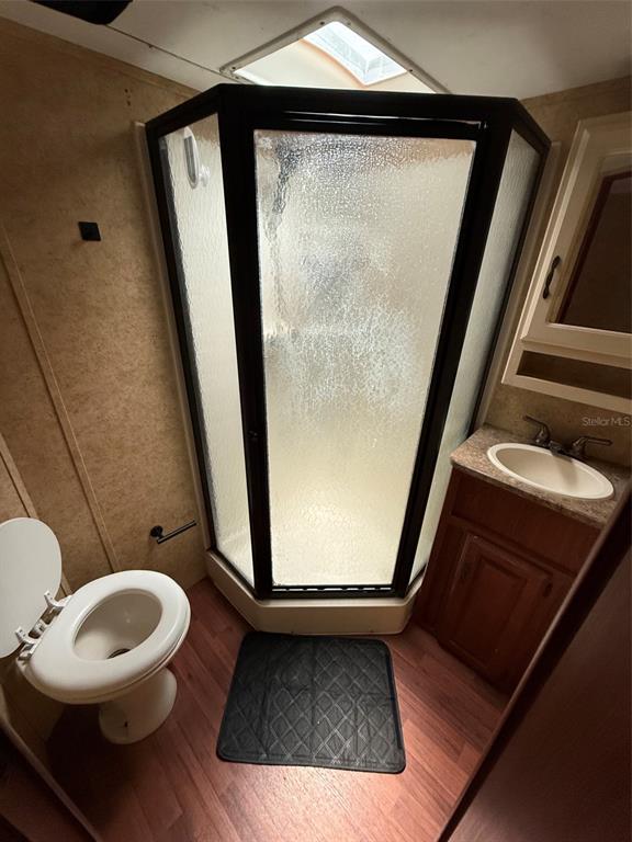 A small bathroom features a corner shower stall, a toilet, and a vanity with sink — 3000 CLARCONA ROAD UNIT 554, APOPKA, FL