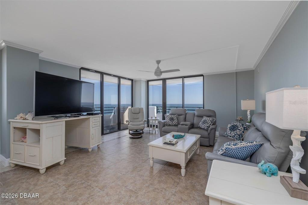 A living room features tile flooring, grey furniture, a white coffee table, and ocean views — 1420 N ATLANTIC AVENUE UNIT 1601, DAYTONA BEACH, FL
