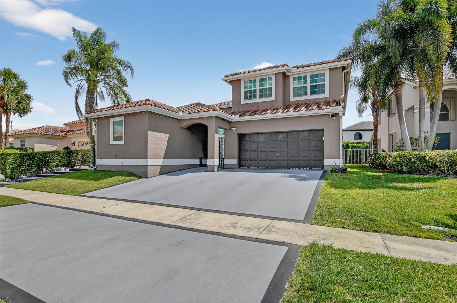 A two-story suburban house with a brown stucco exterior, tile roof, and a concrete driveway — 11038 Baybreeze Way, Boca Raton FL 33428, BOCA RATON, FL