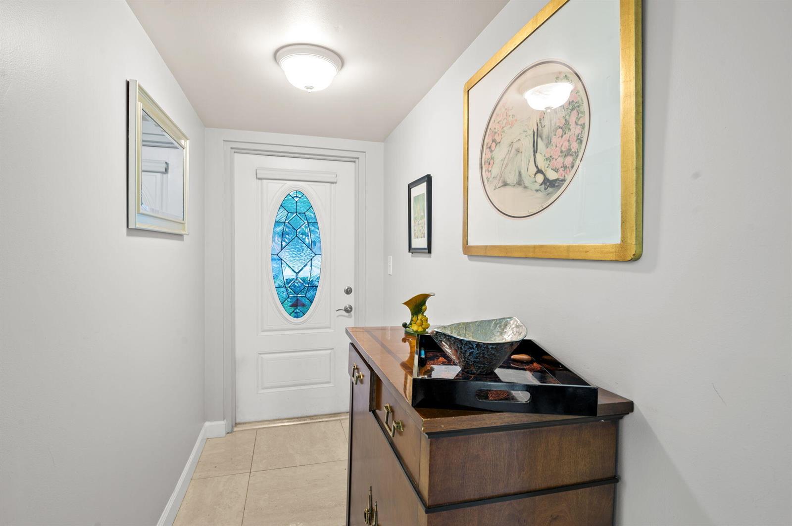 A bright entryway features a white front door with a blue stained-glass oval window — 9330 E Sunrise Lakes Boulevard E # 104, Sunrise FL 33322, SUNRISE, FL