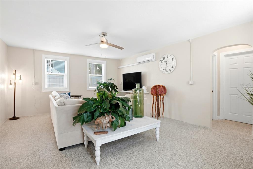 A living room features a white sofa, a coffee table with plants, and a wall clock — 14135 PALM STREET, MADEIRA BEACH, FL