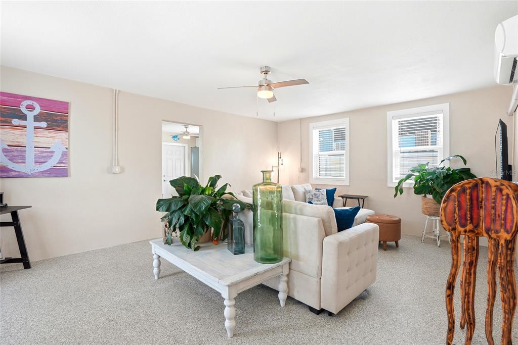 A living room features a beige sofa, a white coffee table, and a ceiling fan — 14135 PALM STREET, MADEIRA BEACH, FL