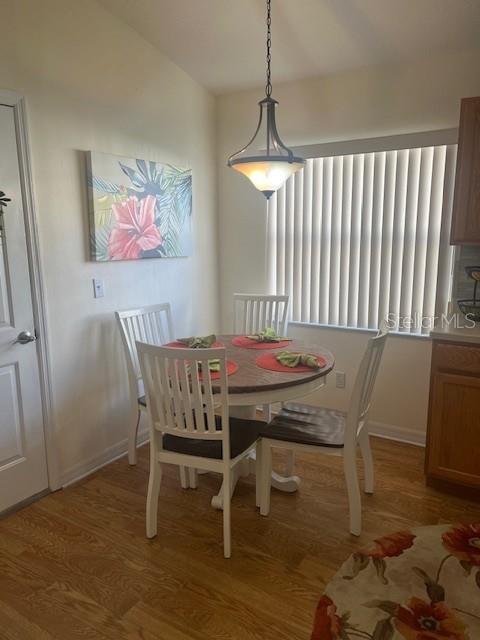 A dining area features a round wooden table with four chairs under a pendant light — 9015 SW 96TH TERRACE, OCALA, FL