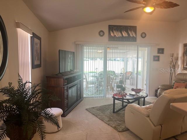 A living room features a television on a media console, a recliner, and sliding doors — 9015 SW 96TH TERRACE, OCALA, FL