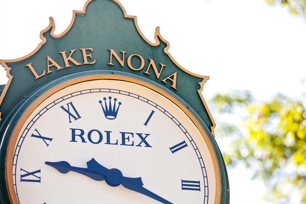 A close-up view of a Rolex clock face mounted under a Lake Nona sign — 11091 CROMWELL ROAD, ORLANDO, FL