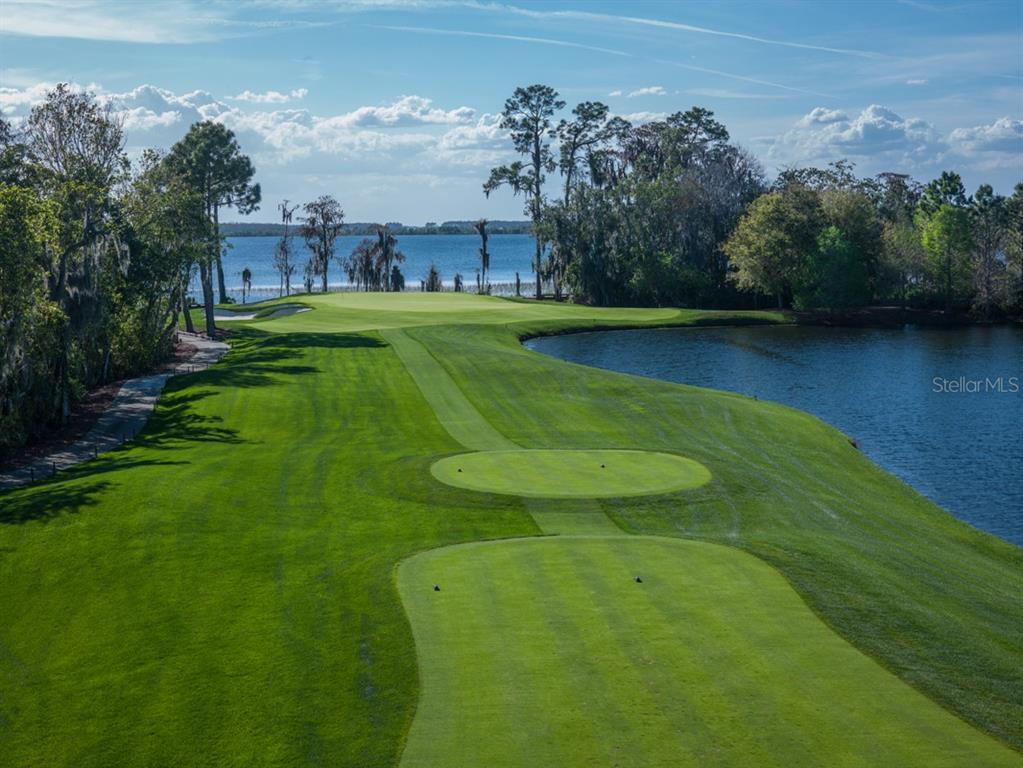 A golf course hole features a green, a fairway, and a pond near a lake — 11091 CROMWELL ROAD, ORLANDO, FL