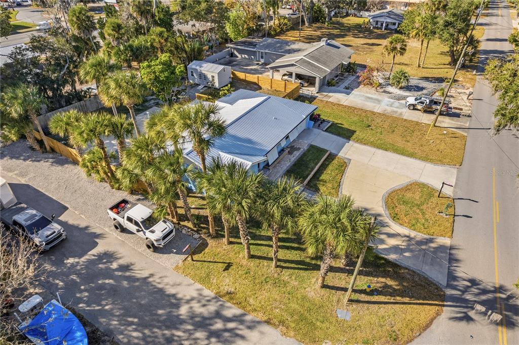 An aerial view shows a house with a metal roof, palm trees, and a driveway — 1000 FAULKNER STREET, NEW SMYRNA BEACH, FL