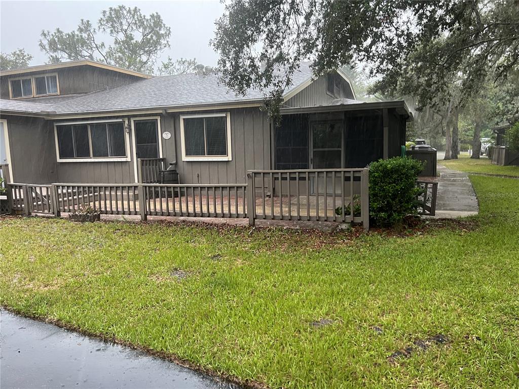 A gray house with a wooden deck, screened-in porch, and a grassy yard — 79 CYPRESS POND ROAD UNIT 79, PORT ORANGE, FL