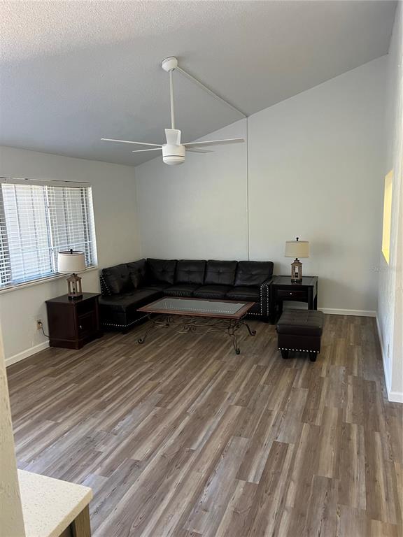 A living room features a black sectional sofa, a coffee table, and wood-look flooring — 79 CYPRESS POND ROAD UNIT 79, PORT ORANGE, FL