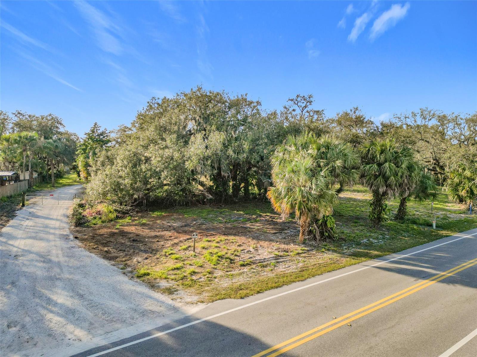 An aerial view shows a vacant, partially cleared lot bordered by a road and trees — 995 Old Dixie Highway, Vero Beach FL 32962, VERO BEACH, FL