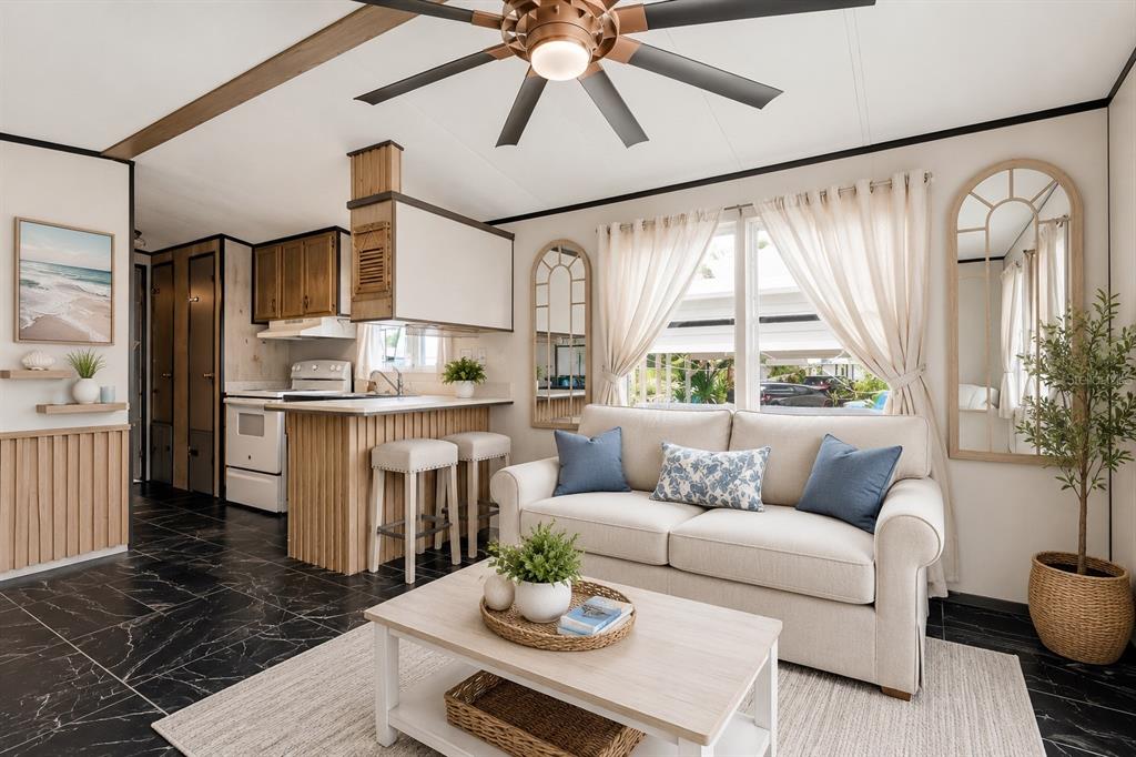 A living room with a sofa, coffee table, and an adjacent kitchen with bar seating — 9000 US HIGHWAY 192 UNIT 11, CLERMONT, FL