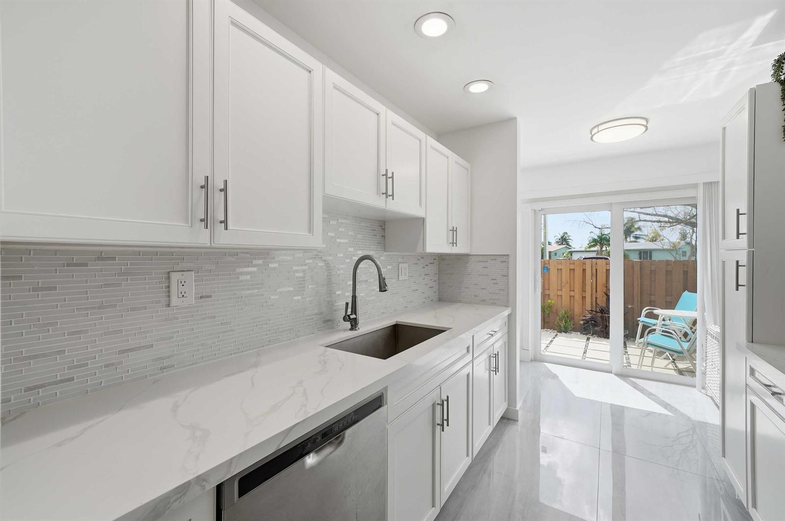 A two-story townhouse exterior features a fenced entrance and two designated parking spaces in front — 10875 NW 29th Manor # 8, Sunrise FL 33322, SUNRISE, FL