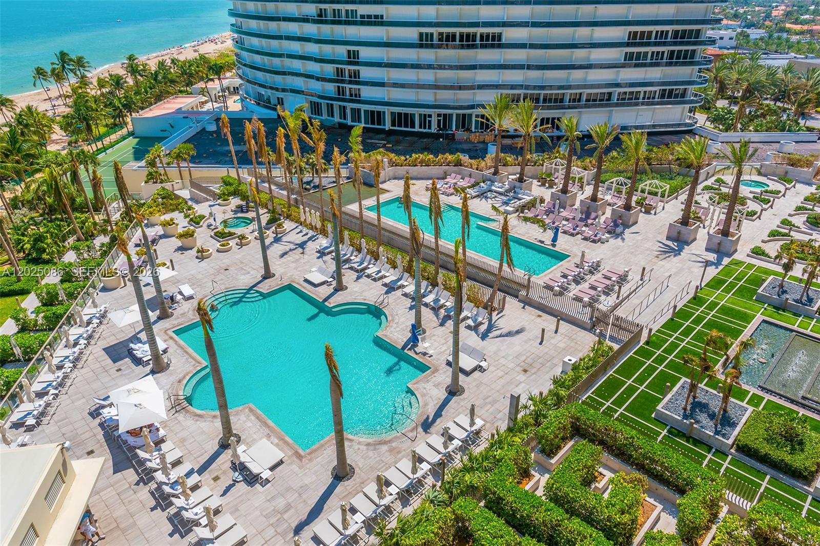 An aerial view shows a large resort pool deck with palm trees and lounge chairs — 9701 Collins Ave # 2001S, Bal Harbour FL 33154, BAL HARBOUR, FL