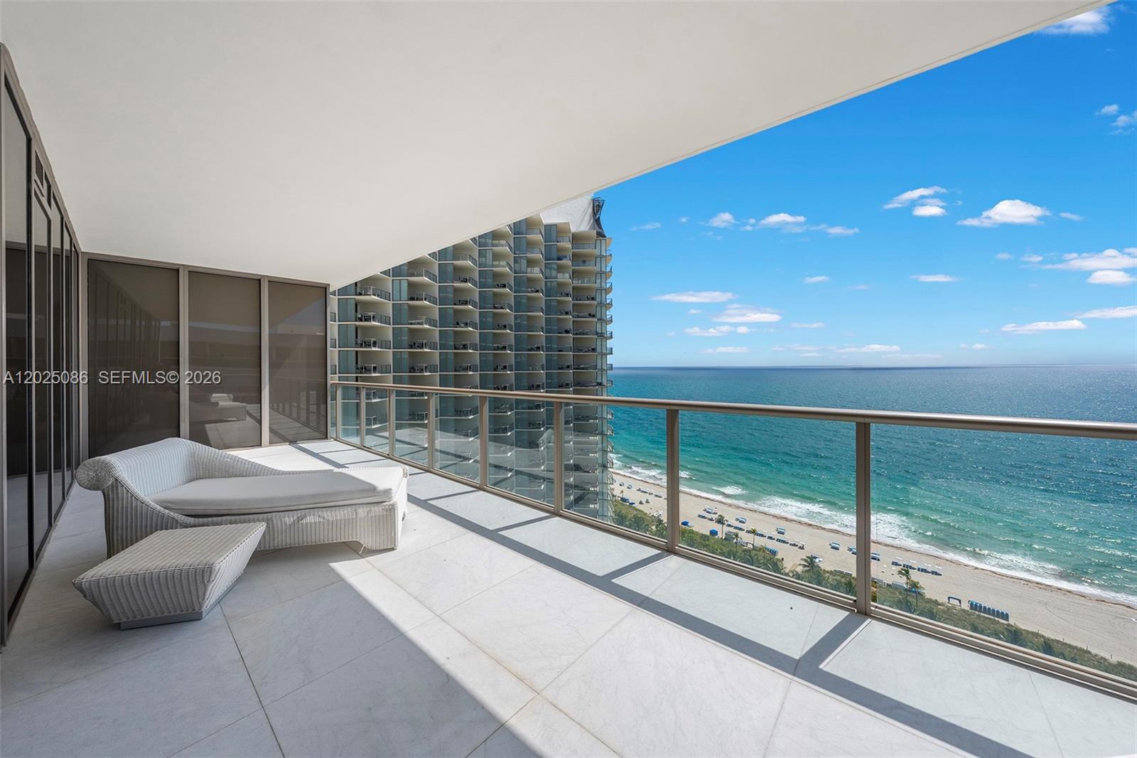 A balcony with white tile flooring and a lounge chair overlooks the ocean and beach — 9701 Collins Ave # 2001S, Bal Harbour FL 33154, BAL HARBOUR, FL