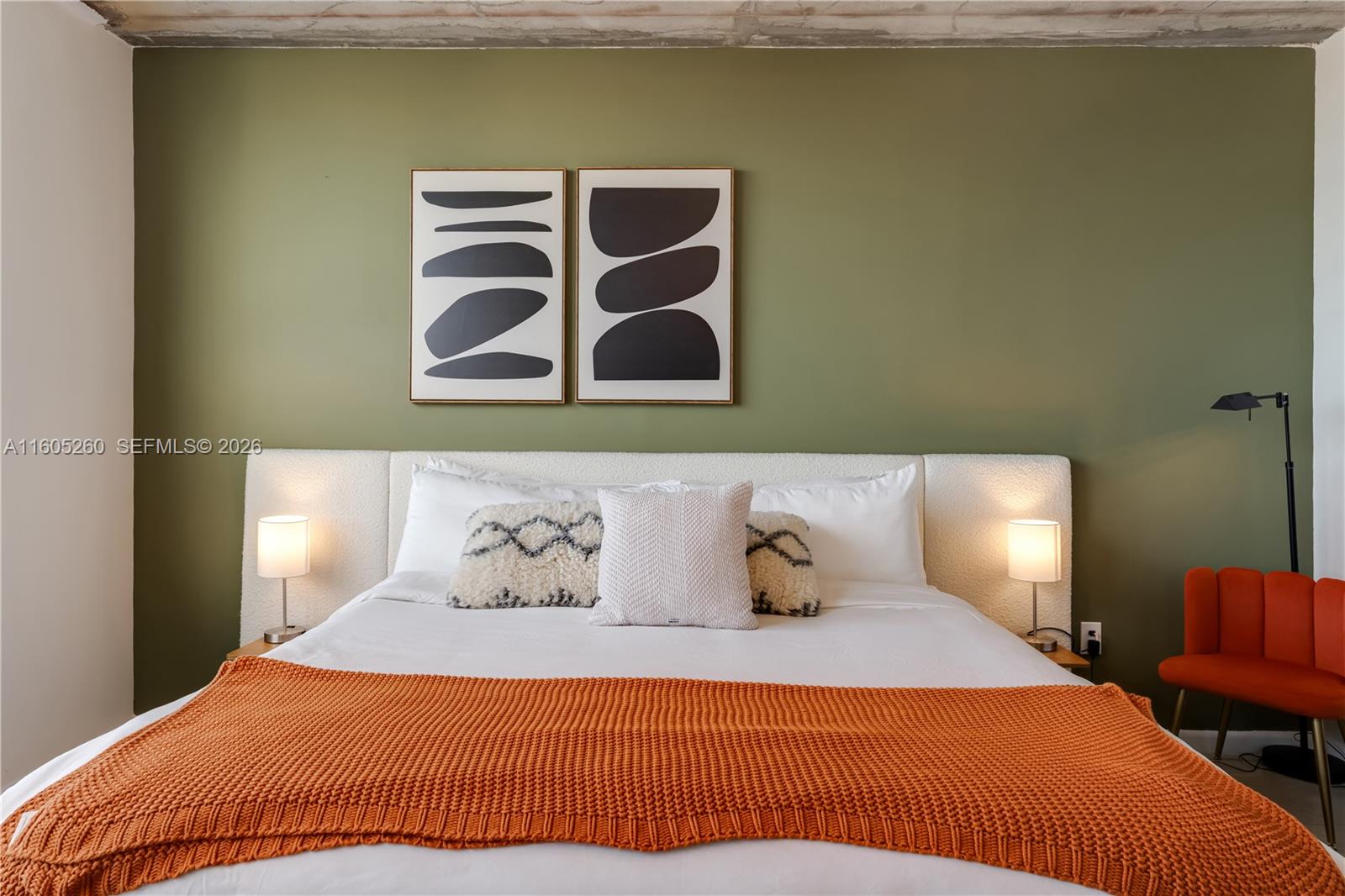 A bedroom features a green accent wall, a white headboard, and an orange throw blanket — 3250 NE 1st Ave # 715, Miami FL 33137, MIAMI, FL