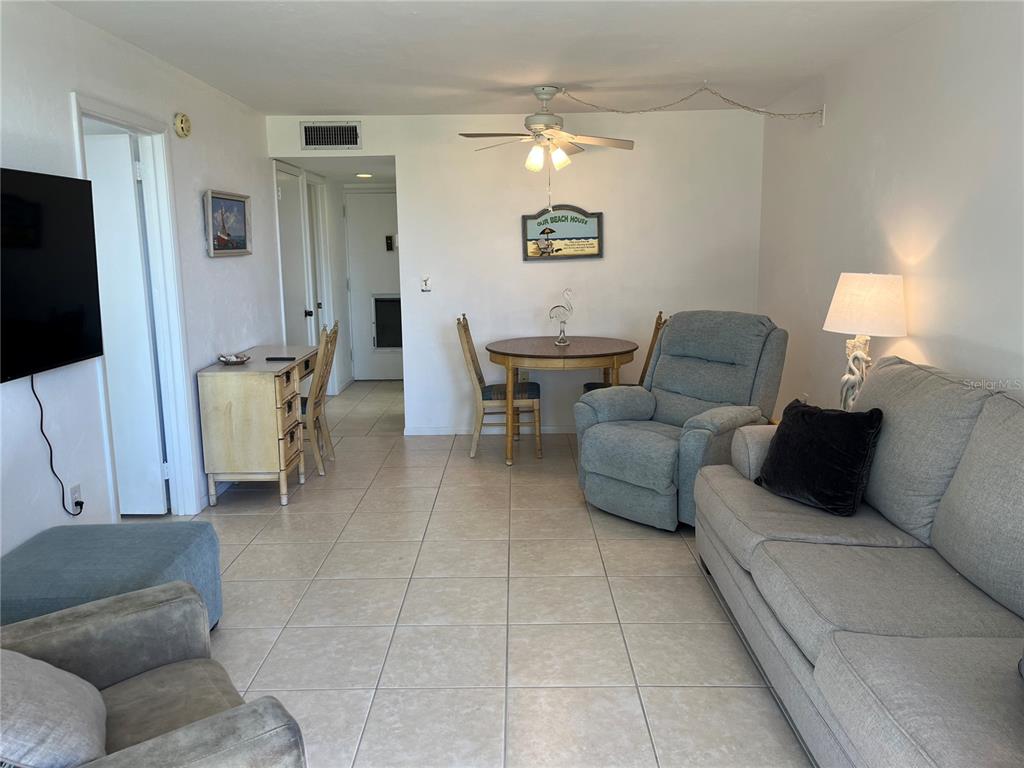 A living room features tile flooring, a dining area, a ceiling fan, and neutral walls — 612 BIRD BAY DRIVE S UNIT 112CAR, VENICE, FL