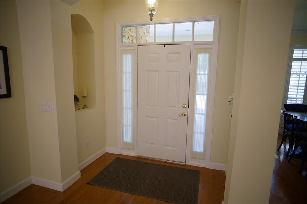 An entryway features a white front door with sidelights, a transom window, and hardwood floors — 6873 SCYTHE AVENUE, ORLANDO, FL