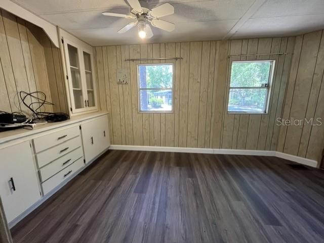 An empty room features wood-paneled walls, a ceiling fan, and white built-in cabinetry — 223 PEPPERTREE COURT, LAKE MARY, FL