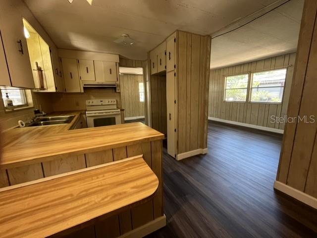 A kitchen with wood-paneled cabinets and a breakfast bar opens into a living area — 223 PEPPERTREE COURT, LAKE MARY, FL