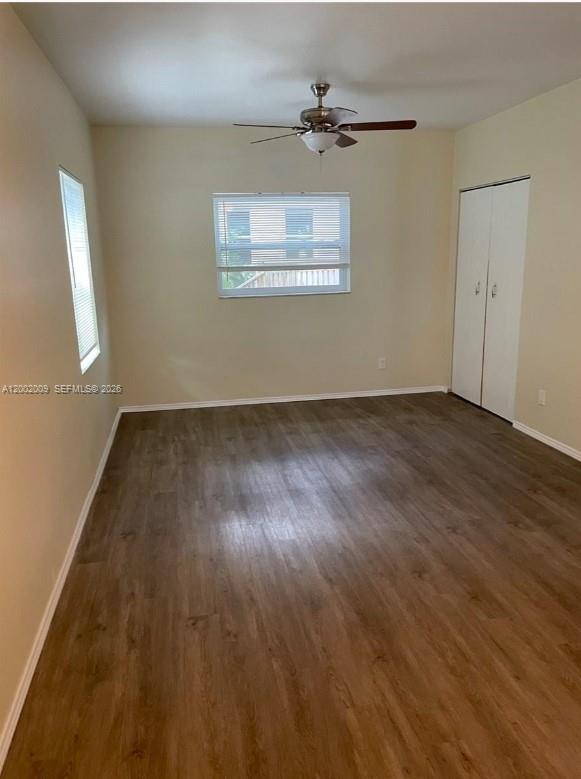 An empty room features wood-look flooring, a ceiling fan, a window, and a white closet — 1720 Pierce St # 1, Hollywood FL 33020, HOLLYWOOD, FL