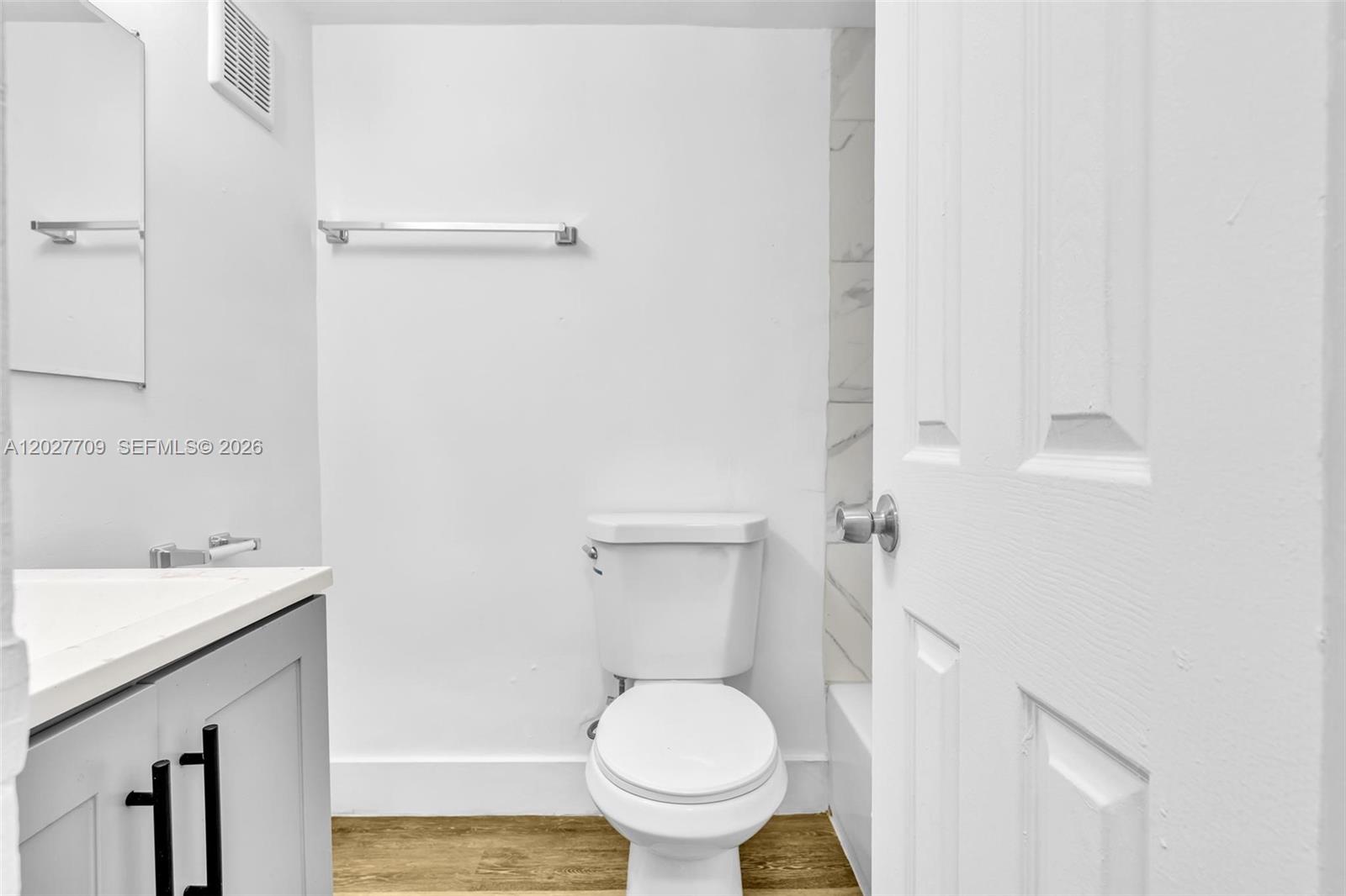 A bathroom features a white toilet, a grey vanity, and a towel rack on the wall — 1000 NW 95th Ter # 103, Miami FL 33150, MIAMI, FL
