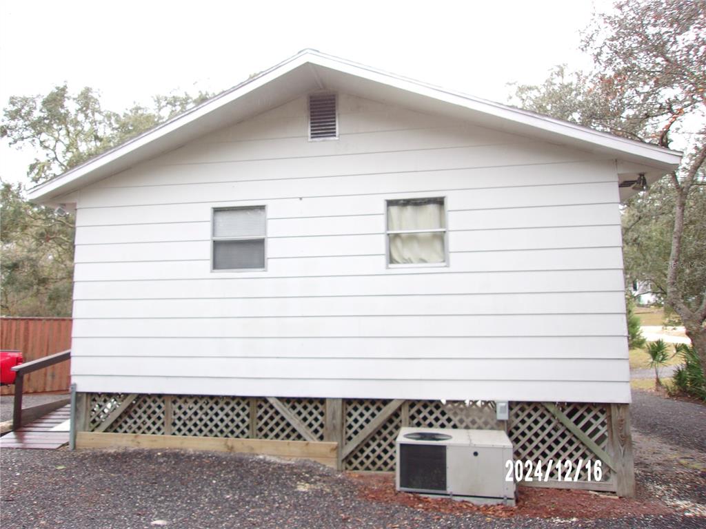 The exterior of a white house features horizontal siding, two windows, and lattice skirting — 17935 SE 10TH PLACE, SILVER SPRINGS, FL