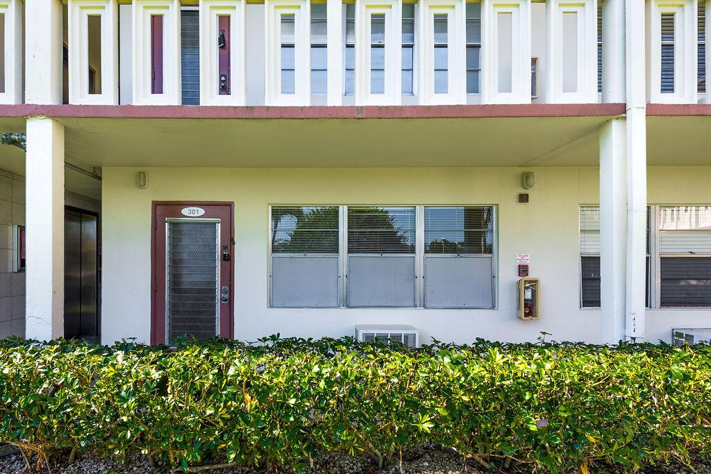 The exterior of a multi-story apartment building features a ground-floor unit with a numbered door — 301 Preston H # 301, Boca Raton FL 33434, BOCA RATON, FL
