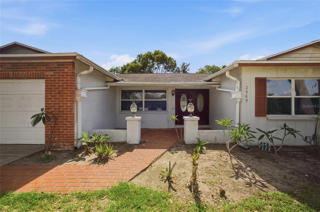 A single-story house features a brick-accented garage, a brick walkway, and a front entrance — 2969 FOREST CIRCLE, SEFFNER, FL