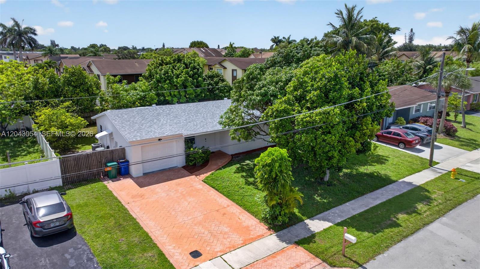 An aerial view shows a single-story house with a white exterior, garage, and paved driveway — 2640 NW 67th Ter, Margate FL 33063, MARGATE, FL