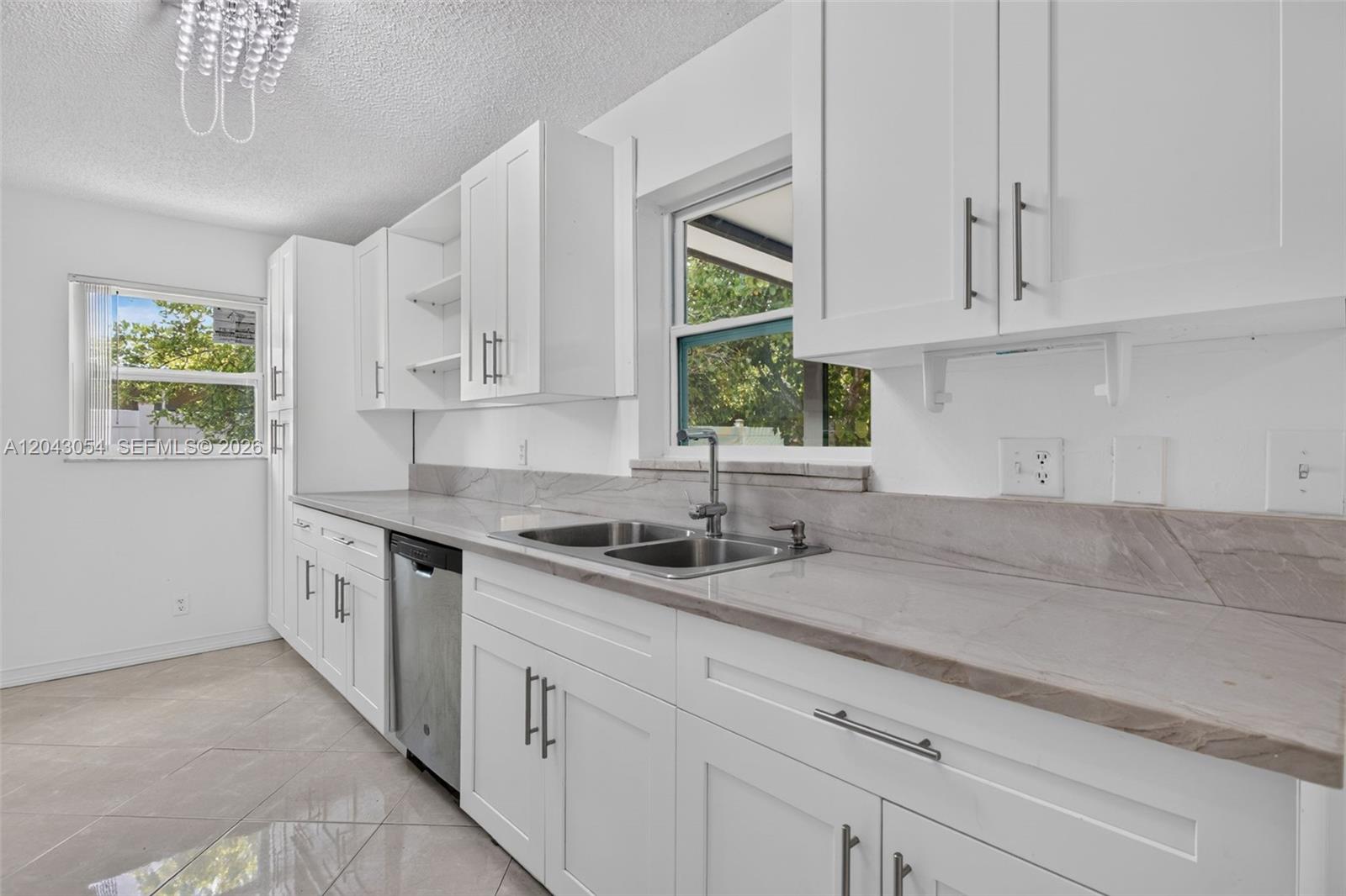 A kitchen features white cabinets, stainless steel appliances, and light-colored stone countertops — 2640 NW 67th Ter, Margate FL 33063, MARGATE, FL