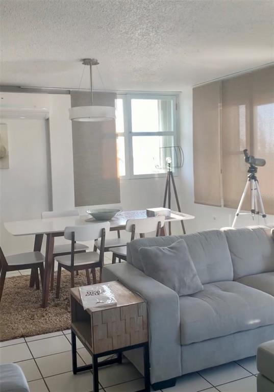An outdoor balcony with tiled flooring overlooks a beach with palm trees and the ocean — 4939 ISLA VERDE AVE. UNIT 601, CAROLINA, PR