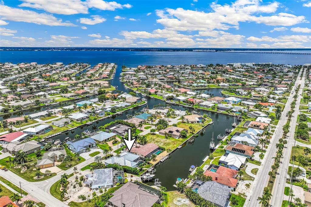 An aerial view shows a waterfront house with a pool and dock along a canal — 2477 SIERRA LANE, PUNTA GORDA, FL