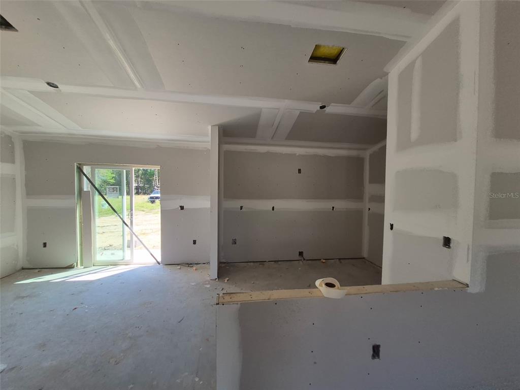 An unfinished room with drywall, a sliding glass door, and exposed electrical boxes — 7640 SW 14 STREET, OCALA, FL