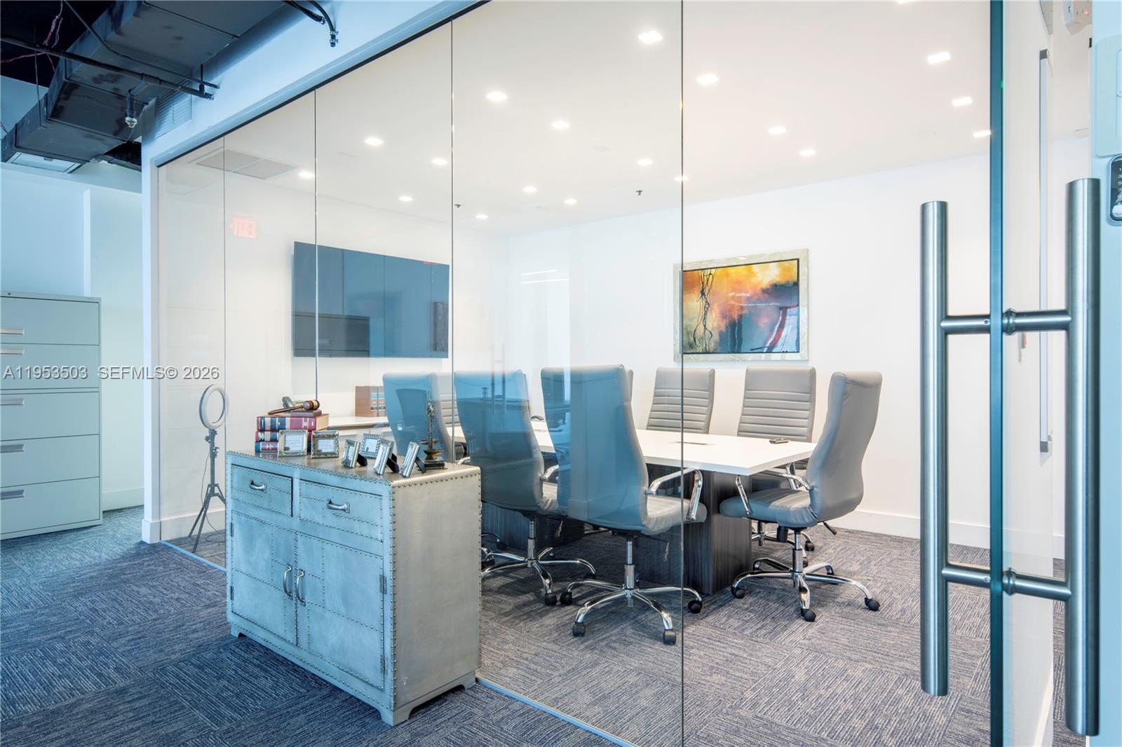 A glass-enclosed conference room features a white table, gray chairs, and a metal cabinet — 150 SE 2nd Ave # 1410, Miami FL 33131, MIAMI, FL