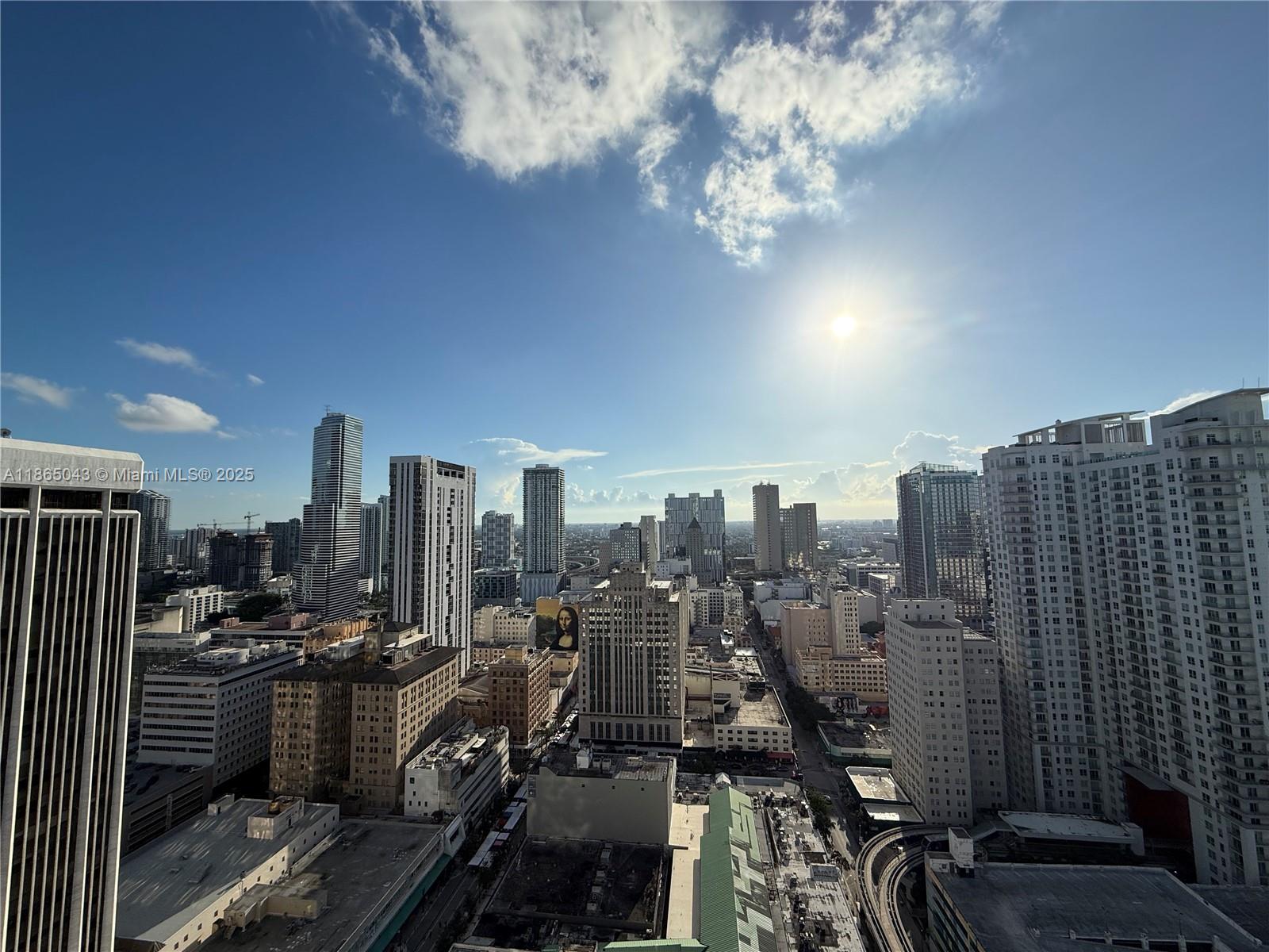 An elevated view of a dense city skyline featuring numerous high-rise buildings under a sunny sky — 50 Biscayne Blvd # 3405, Miami FL 33132, MIAMI, FL